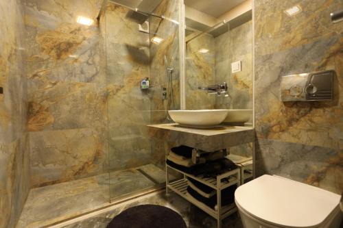a bathroom with a sink and a toilet at Apartments Lux in city center Lviv in Lviv