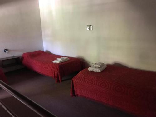 two beds in a room with red sheets at Casablanca in Victoria