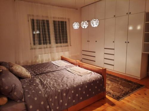 Schlafzimmer mit einem Bett, Schränken und einem Fenster in der Unterkunft Stan na dan Bijeljina Tijana in Bijeljina