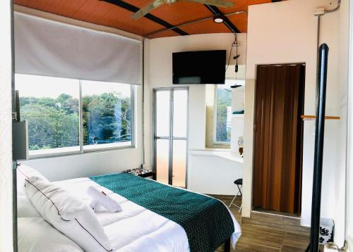 1 dormitorio con cama y ventana grande en Hostal Bon Hábitat en Yopal