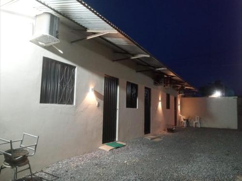 - un bâtiment blanc avec terrasse la nuit dans l'établissement Quarto Suíte independente da casa com garagem, à Carolina