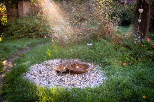 a garden with a bird bath in the grass at ENJOY Cozy HOME Hills & Forest & Views & Gardens & Sauna Whirlpool Bath in Jablonné v Podještědí