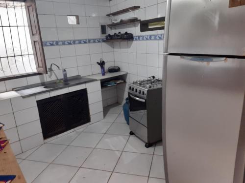 cocina blanca con nevera y fogones en Arraial Casinha Centro en Arraial d'Ajuda
