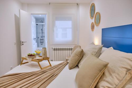 um quarto com uma cama com almofadas e uma mesa em Apartamento San Pedro em Santiago de Compostela