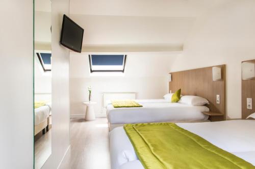 A bed or beds in a room at Hotel Bel Oranger Gare de Lyon