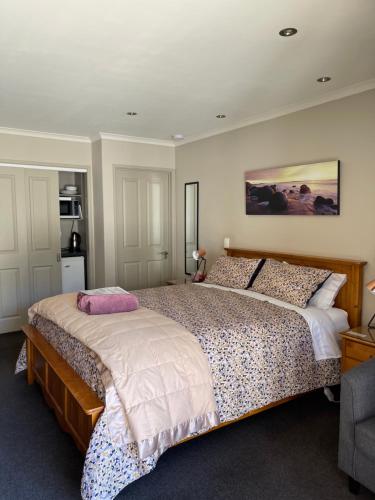 um quarto com uma cama grande e uma almofada cor-de-rosa em Cromwell Getaway em Cromwell