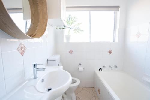 baño con lavabo y aseo y ventana en LUXURIOUS BEACH FRONT APARTMENT cronulla en Burraneer