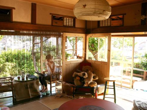 uma sala de estar com janelas e um urso de peluche em The Otaornai Backpacker's Hostel Morinoki em Otaru