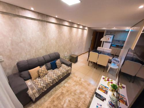 uma sala de estar com um sofá e uma sala de jantar em Maceió Facilities Temporada na Ponta Verde em Maceió