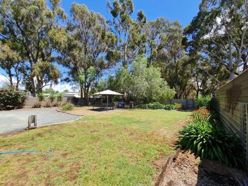 a yard with a picnic table and an umbrella at Kyabram Country Motel in Kyabram