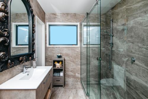 a bathroom with a glass shower and a sink at Boathouse Apartments in Picton