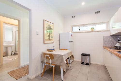 a kitchen with a table and a refrigerator at Arcadia Apartment - Cottesloe in Perth