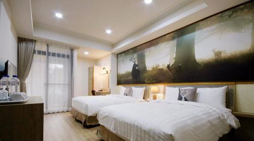 a hotel room with two beds and a large painting on the wall at 逐鹿森林民宿-無電梯 in Yuchi