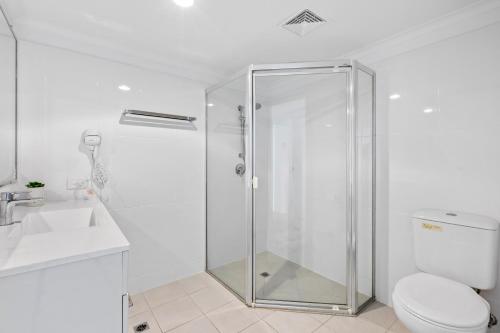 a bathroom with a shower and a toilet and a sink at Northwind Beachfront Apartments in Mooloolaba