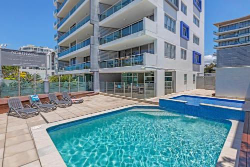 a swimming pool in front of a building at Northwind Beachfront Apartments in Mooloolaba