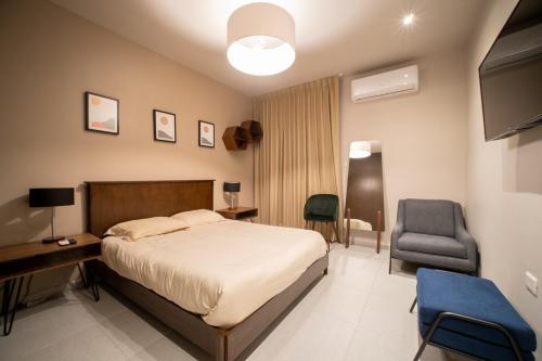 1 dormitorio con cama, escritorio y silla en PENINSULA STAYS 2 BR Designer Apartment & 200 MB FAST WIFI New Listing!, en Mérida