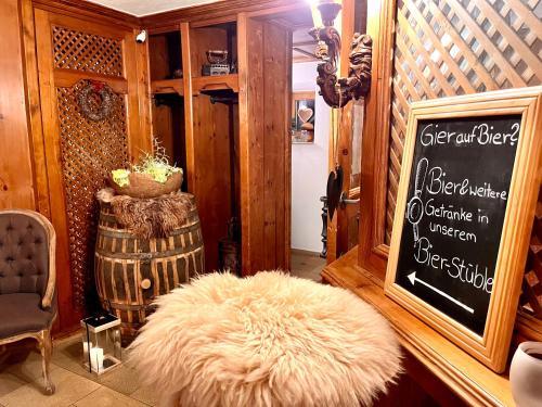 ウルムにあるAm Zehntstadl Hotel & Saunaの白毛のオットマンと看板のある部屋