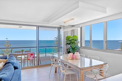 a living room with a table and a view of the ocean at Northwind Beachfront Apartments in Mooloolaba