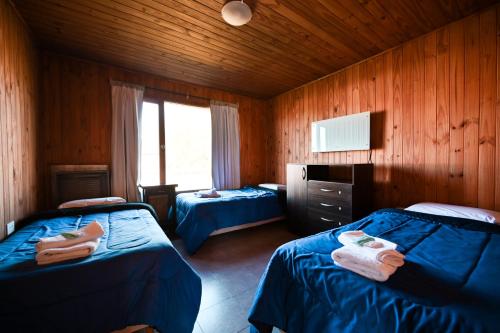 佩里托莫雷諾冰川的住宿－Las Moras Cabañas，一间卧室配有两张床和电视。