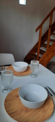 a table with three bowls and glasses on it at La Guanaca in Perito Moreno