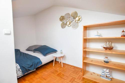 een slaapkamer met een bed en een boekenplank bij Apartment Emil in Biograd na Moru