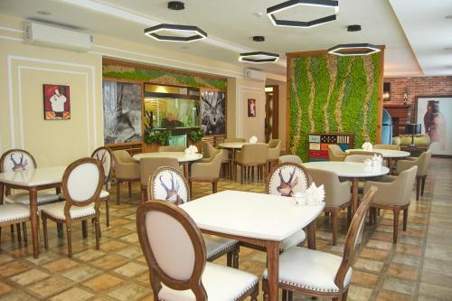 a restaurant with tables and chairs in a room at GREEN Which Hotel in Petropavlovsk