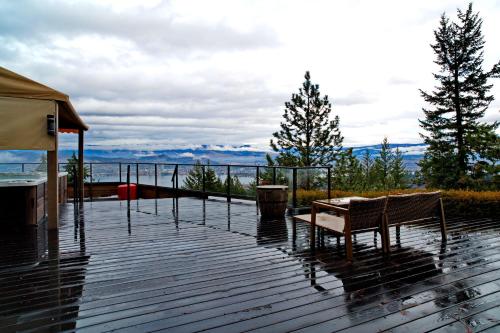 a wooden deck with a table and chairs on it at Honeymoon Suite in West Kelowna