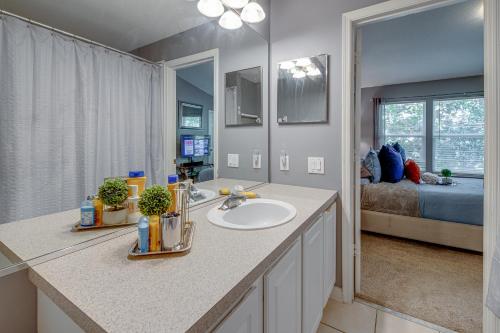 a bathroom with a sink and a bedroom with a bed at The Lux At Lake Mary in Lake Mary