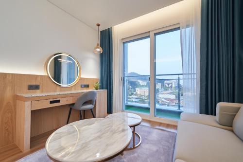 a living room with a table and a large window at JN PARK Hotel in Incheon