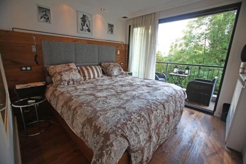 a bedroom with a large bed and a balcony at George Apartment in Neuilly in Neuilly-sur-Seine