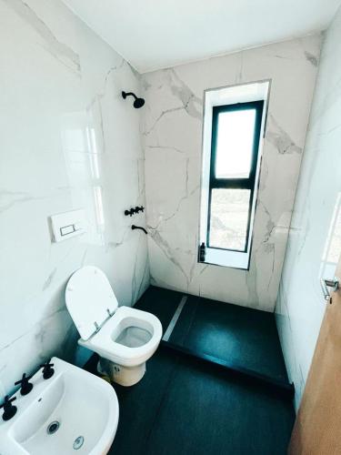 a bathroom with a white toilet and a sink at Cabaña La Alemana in Villa Berna