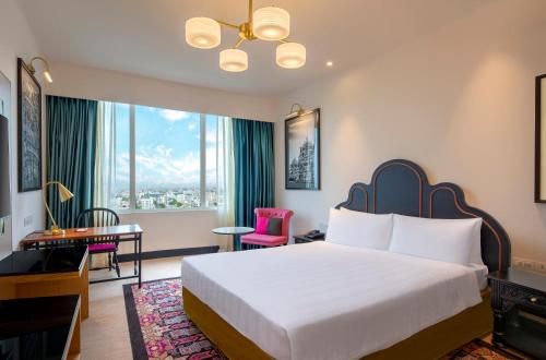 a hotel room with a large bed and a desk at Welcomhotel By ITC Hotels, Guntur in Guntūr