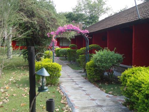 a garden with a pathway leading to a red house at Mara River Lodge in Aitong
