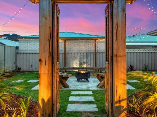 a patio with a table and a fire place at Waves on Whitesands in Fingal Bay
