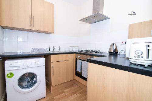 una cocina con lavadora y secadora en una encimera en 5Blythe House Apartments Brierley Hill en Birmingham