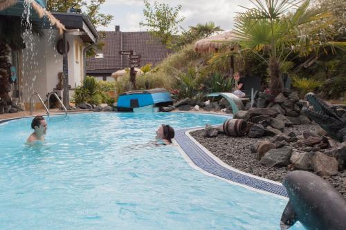a group of people in a swimming pool at Landhotel Grimmeblick in Winterberg