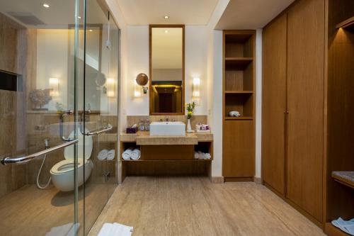 a bathroom with a toilet and a sink and a shower at Grand Inna Kuta in Kuta