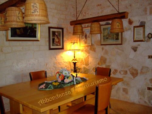 une salle à manger avec une table en bois et des fleurs. dans l'établissement Room in BB - Abbondanza The Farm House, à Alberobello