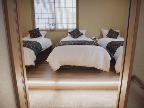 two beds in a room with a mirror at Ixyz別邸 月夜見の宿 in Nagoya