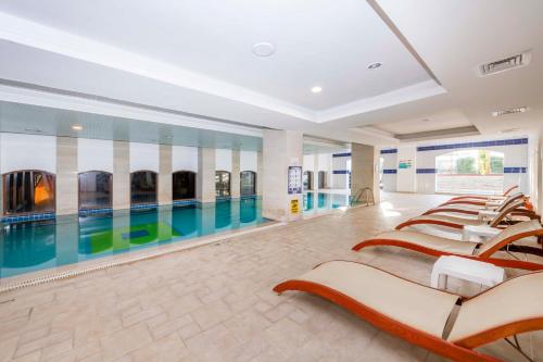 a swimming pool with a row of chairs in a building at Armas Labada in Kemer