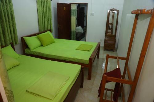 a living room with two beds and a chair at FOREST VIEW HOME STAY in Anuradhapura