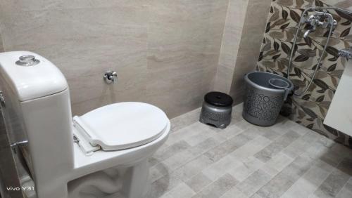 a bathroom with a toilet and a trash can at Hotel Pragatti in Jalandhar