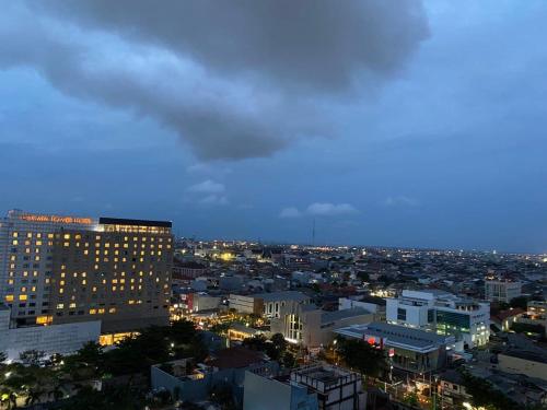ein Blick auf eine Stadt bei Nacht in der Unterkunft MG Suites 1 Bedroom Apartment Sea View Semarang (KUMU SUITES) in Semarang