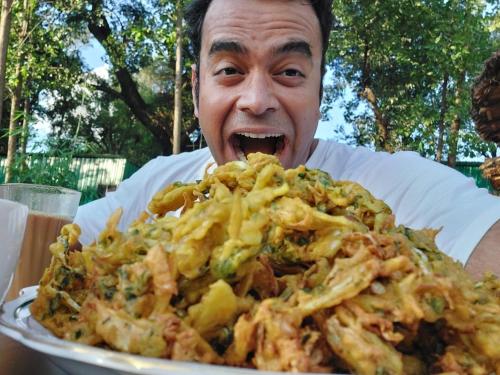 a man is eating a large plate of food at Dev Bhoomi Farms & Cottages in Dharamshala