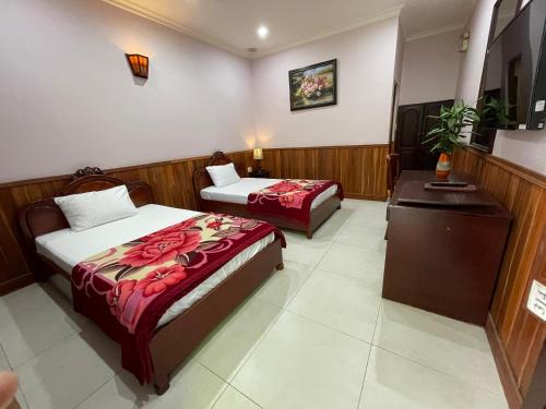 a hotel room with two beds and a desk at Song Tra Hotel in Xóm Phước Mỹ