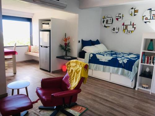 - une petite chambre avec un lit et une chaise dans l'établissement Studio Teiki - calme, proche centre-ville, ferry & aéroport, à Papeete