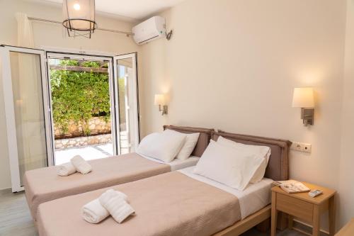 dwa łóżka w pokoju z oknem w obiekcie Kefalonia View Villas w mieście Karavomylos