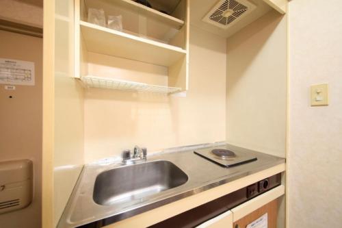 uma cozinha com um lavatório num pequeno quarto em Monthly Mansion Tokyo West 21 - Vacation STAY 10866 em Fuchu