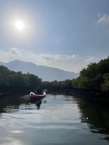 a man is in a boat on a river at Lazeemah Chalet استراحة اللزيمه in Ras al Khaimah