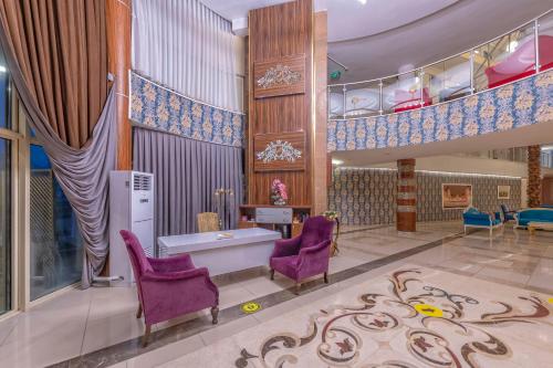 a lobby with purple chairs and a table and stairs at Armas Beach in Kemer